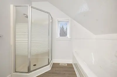 a glass shower in a white bathroom with a window at Luxurious Private House Pool and Hot Tub in Blue Mountains