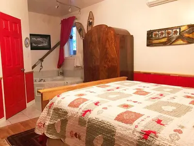 a bedroom with a bed and a bathroom with a tub at Our Valley View Bed & Breakfast in Hampton
