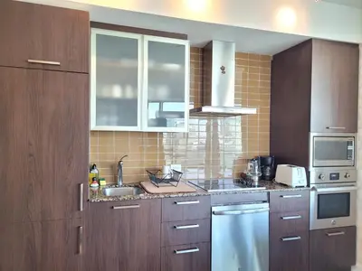 a kitchen with wooden cabinets and a sink at Two BD CN Tower and Lake Ontario View in Toronto
