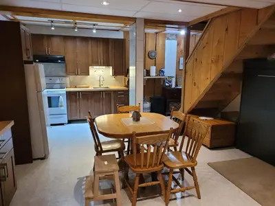 a kitchen with a wooden table and chairs in a room at Whispering Pines Suite at The Bowering Lodge in Blue Mountains