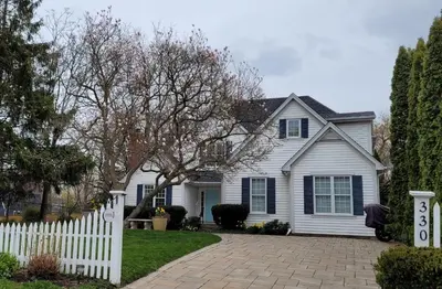 a white house with a white picket fence at La Maison de Sophie in Niagara on the Lake