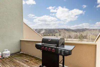 a grill on a balcony with a view of the mountains at Stunning Townhouse - 3 BDRM Blue Mountain Village Sauna! in Blue Mountains