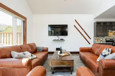 a living room with brown leather couches and a tv at Luxury Mountain Retreat with private hot tub 82958 in Blue Mountains