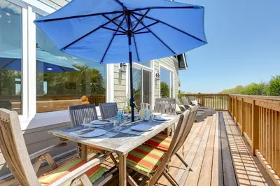 a wooden table with a blue umbrella on a deck at Luxury Mountain Retreat with private hot tub 82958 in Blue Mountains