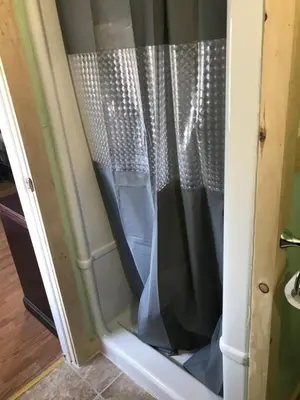 a shower door with a curtain in a room at Earthquest Lodge in Port Burwell