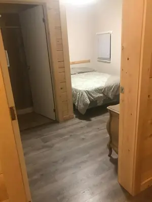 a bedroom with a bed and a door leading into a room at Earthquest Lodge in Port Burwell