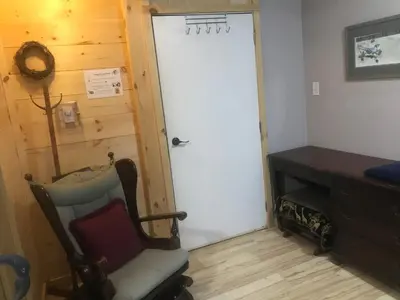 a door in a room with a chair and a desk at Earthquest Lodge in Port Burwell