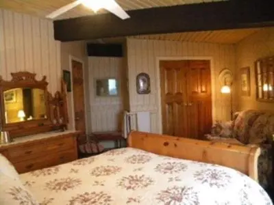 a bedroom with a bed and a couch in it at Stouffermill Bed & Breakfast in Algonquin Highlands