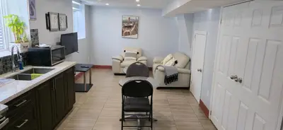 a kitchen with two chairs and a sink and a door at Prestige Accommodation in Ajax