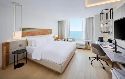 a white bedroom with a large bed and a desk at The Pearle Hotel & Spa, Autograph Collection in Burlington