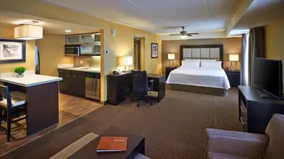 a hotel room with a bed and a living room at Homewood Suites by Hilton Hamilton in Hamilton