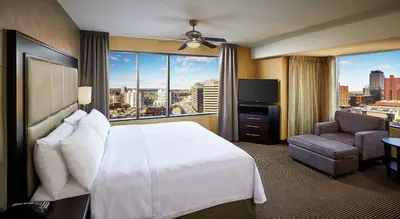 a hotel room with a bed and a large window at Homewood Suites by Hilton Hamilton in Hamilton