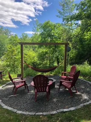 a patio with three chairs and a swing at The hidden nest in Marmora