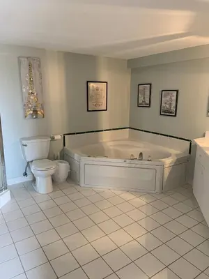 a large bathroom with a tub and a toilet at The Jypsy Inn Chambre Damour Bracebridge in Bracebridge