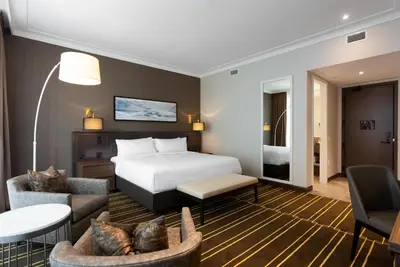 a hotel room with a bed and a living room at Sutton Place Hotel Toronto in Toronto