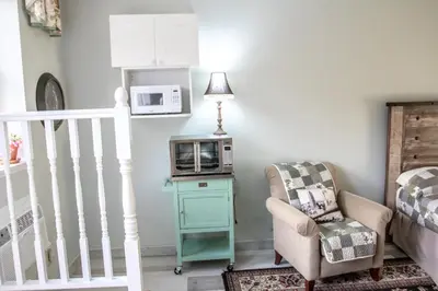 a living room with a microwave and a chair at The Jypsy Inn / Fifth Avenue in Bracebridge