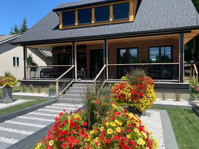 a house with a bunch of flowers in front of it at 33 On Gage Garden Suite in Niagara on the Lake
