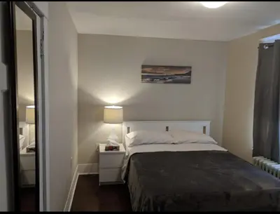 a small bedroom with a bed and a mirror at House in Niagara falls, Close to Clifton Hill, Casino and Horseshoe falls and with kitchen for 6 Guest in Niagara Falls