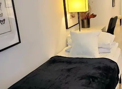 a bedroom with a bed with white pillows and a lamp at Stylish Downtown Toronto Residential Hotel in Toronto