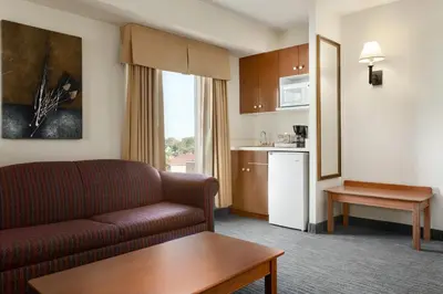 a living room with a couch and a kitchen at Days Inn by Wyndham Niagara Falls Centre St By the Falls in Niagara Falls