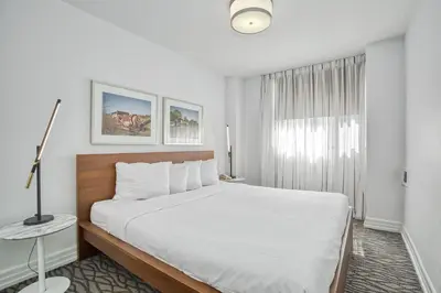 a white bedroom with a large bed and a window at Town Inn Suites Hotel in Toronto