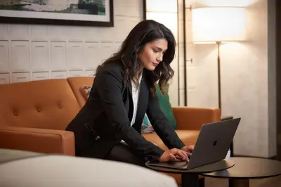 a woman sitting in front of a laptop computer at Stay Inn Hotel Toronto in Toronto