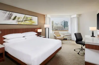 a hotel room with a large white bed and a desk at Delta Hotels by Marriott Toronto Mississauga in Mississauga
