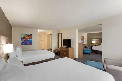 a hotel room with two beds and a flat screen tv at Best Western Plus Toronto Airport Hotel in Mississauga