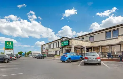 a parking lot with cars parked in front of a building at Quality Inn Toronto Airport in Mississauga