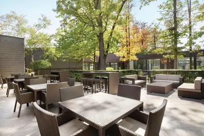 a patio with tables and chairs and trees at DoubleTree by Hilton Hotel Toronto Airport West in Mississauga