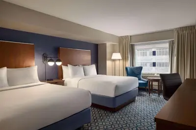 a hotel room with two beds and a desk at Wyndham Grand Fallsview Hotel in Niagara Falls