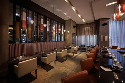 a restaurant with tables and chairs and windows at Pantages Hotel Toronto Centre in Toronto