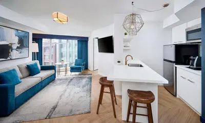 a living room with a couch and a kitchen at Pantages Hotel Toronto Centre in Toronto