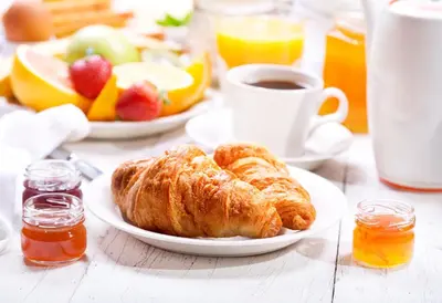 a table with a plate of pastries and a cup of coffee at Executive Hotel Cosmopolitan Toronto in Toronto