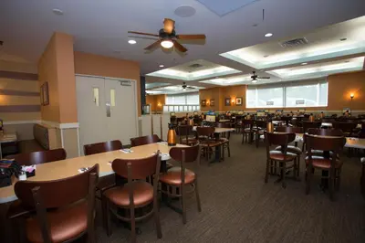 a dining room with wooden tables and chairs at Ramada by Wyndham Niagara Falls/Fallsview in Niagara Falls