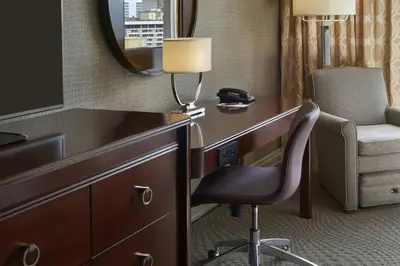 a desk in a hotel room with a chair and a lamp at Sheraton Centre Toronto Hotel in Toronto
