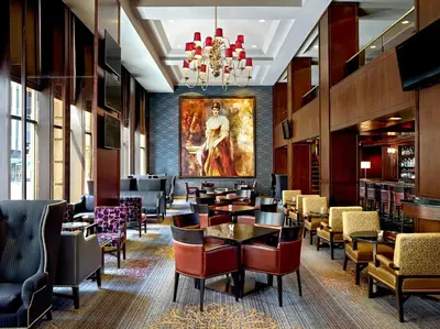 a restaurant with tables and chairs and a painting on the wall at The Omni King Edward Hotel in Toronto