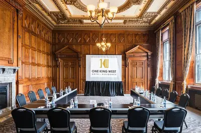 a meeting room with a table and chairs and a screen at One King West Hotel and Residence in Toronto