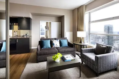 a living room with a couch and a table at One King West Hotel and Residence in Toronto