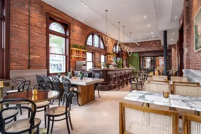 a restaurant with tables and chairs and a bar at Gladstone House in Toronto