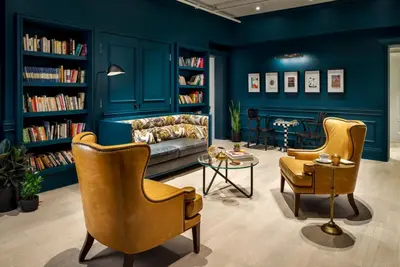 a living room with a couch and chairs and books at Gladstone House in Toronto