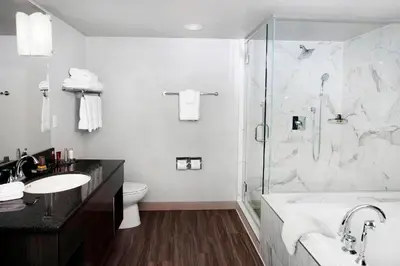 a bathroom with a shower and a tub and a sink at Niagara Falls Marriott on the Falls in Niagara Falls