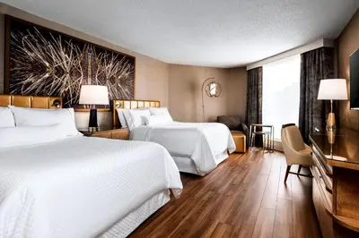 a hotel room with two beds and a television at The Westin Toronto Airport in Toronto