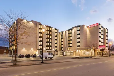 a large building with a white van parked in front of it at Ramada By Wyndham Niagara Falls near the Falls in Niagara Falls