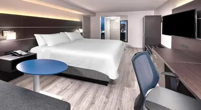 a hotel room with a bed and a table and a couch at Holiday Inn Express & Suites Mississauga-Toronto Southwest by IHG in Mississauga