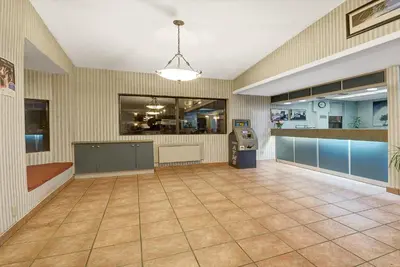 a large empty room with a bar and a restaurant at Super 8 by Wyndham Niagara Falls North in Niagara Falls