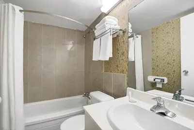 a bathroom with a sink and a toilet and a tub at Super 8 by Wyndham Niagara Falls North in Niagara Falls