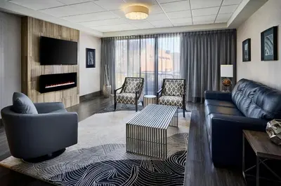 a living room with a couch and chairs and a fireplace at Sheraton Hamilton Hotel in Hamilton