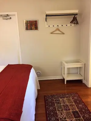 a bedroom with a bed and a table and a rug at Ellis House Bed & Breakfast in Niagara Falls