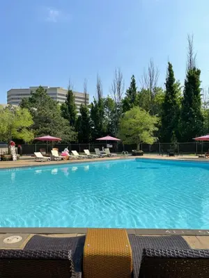 a large swimming pool with chairs and trees at Crowne Plaza Toronto - North York by IHG in Toronto